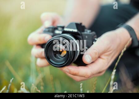 Homme tenant le miroir de l'appareil photo dans le paysage vert Banque D'Images