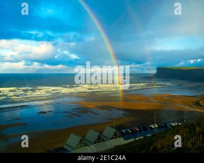 Saltburn Beach en hiver soleil bleu ciel avec un double arc-en-ciel et une vue lointaine de regarder vers la colline de Warsett Banque D'Images