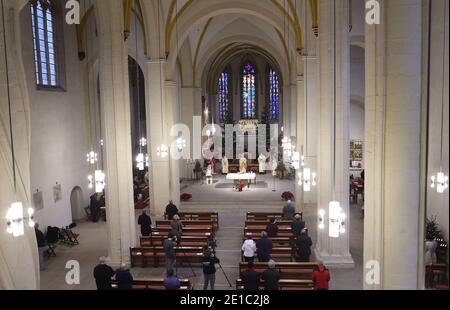 Magdebourg, Allemagne. 06e janvier 2021. Les croyants suivent un service dans la cathédrale catholique romaine de Saint-Sébastien. Les croyants ont célébré la Fête de l'Epiphanie avec un service d'église à Magdebourg mercredi. La fête de l'Epiphanie du 6 janvier est l'une des fêtes les plus importantes pour les catholiques. Le service dans l'église Saint-Sébastien a également été en direct sur Internet cette année. Crédit : Ronny Hartmann/dpa-Zentralbild/dpa/Alay Live News Banque D'Images