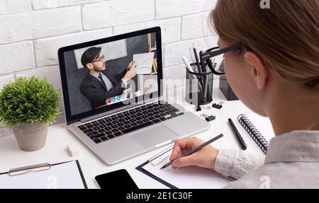 Femme à l'ordinateur portable ayant la consultation en ligne d'affaires dans le bureau Banque D'Images