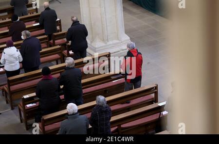 Magdebourg, Allemagne. 06e janvier 2021. Les croyants suivent un service dans la cathédrale catholique romaine de Saint-Sébastien. Les croyants ont célébré la Fête de l'Epiphanie avec un service d'église à Magdebourg mercredi. La fête de l'Epiphanie du 6 janvier est l'une des fêtes les plus importantes pour les catholiques. Le service dans l'église Saint-Sébastien a également été en direct sur Internet cette année. Crédit : Ronny Hartmann/dpa-Zentralbild/dpa/Alay Live News Banque D'Images