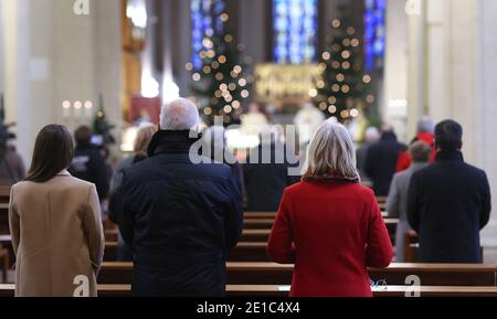 Magdebourg, Allemagne. 06e janvier 2021. Les croyants suivent un service dans la cathédrale catholique romaine de Saint-Sébastien. Les croyants ont célébré la Fête de l'Epiphanie avec un service d'église à Magdebourg mercredi. La fête de l'Epiphanie du 6 janvier est l'une des fêtes les plus importantes pour les catholiques. Le service dans l'église Saint-Sébastien a également été en direct sur Internet cette année. Crédit : Ronny Hartmann/dpa-Zentralbild/dpa/Alay Live News Banque D'Images