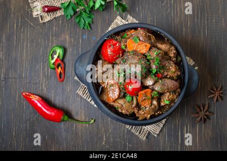 Faire rôtir le foie de dinde avec les légumes dans un pot. Délicieux repas diététique. Style rustique. Vue de dessus, plan d'appartement. Banque D'Images
