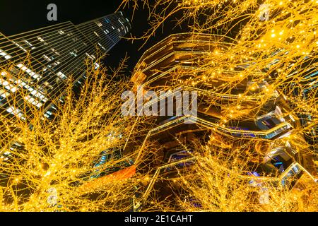 Des arbres de Noël illuminés entourent le bateau dans les cours d'Hudson. Banque D'Images