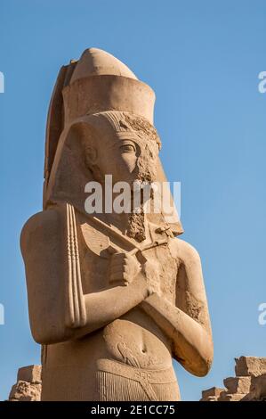 Louxor. C'est la statue de Ramasses II, le Grand à l'entrée du temple de Karnak, vieux de 4000 ans, le plus grand complexe de temples au monde, situé sur le Nil à la ville de Louxor autrefois connue dans le monde antique comme Thèbes. Les terrains du temple ont également été utilisés comme un ensemble de films pour le film James Bond The Spy qui aimait moi. Banque D'Images