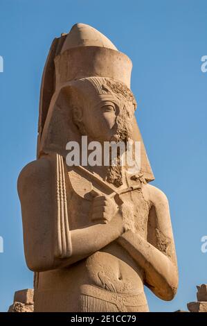 Louxor. C'est la statue de Ramasses II, le Grand à l'entrée du temple de Karnak, vieux de 4000 ans, le plus grand complexe de temples au monde, situé sur le Nil à la ville de Louxor autrefois connue dans le monde antique comme Thèbes. Les terrains du temple ont également été utilisés comme un ensemble de films pour le film James Bond The Spy qui aimait moi. Banque D'Images