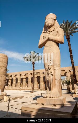 Louxor. Voici la statue de Ramasses II, le Grand avec sa fille Bentanta à ses pieds à l'entrée du temple de Karnak, âgé de 4000 ans, le plus grand complexe de temples du monde, Situé sur le Nil dans la ville de Louxor, autrefois connue dans le monde antique sous le nom de Thèbes. Les terrains du temple ont également été utilisés comme un ensemble de films pour le film James Bond The Spy qui aimait moi. Banque D'Images