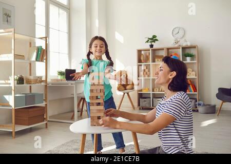 La mère et la fille jouent à des jeux de société dans le salon. Éducation et développement des enfants. Banque D'Images