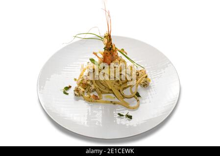 Linguine à la pulpe de crevettes, pâtes typiquement italiennes à spaghetti aux fruits de mer en plaque blanche isolée sur fond blanc Banque D'Images