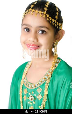 PORTRAIT D'UNE FILLE PORTANT UNE ROBE TRADITIONNELLE ARABE VERTE AVEC BAGUE D'OREILLE DORÉE, BIJOUX DE TÊTE ET DE COU. Banque D'Images