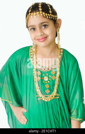 PORTRAIT D'UNE FILLE PORTANT UNE ROBE TRADITIONNELLE ARABE VERTE AVEC BAGUE D'OREILLE DORÉE, BIJOUX DE TÊTE ET DE COU. Banque D'Images