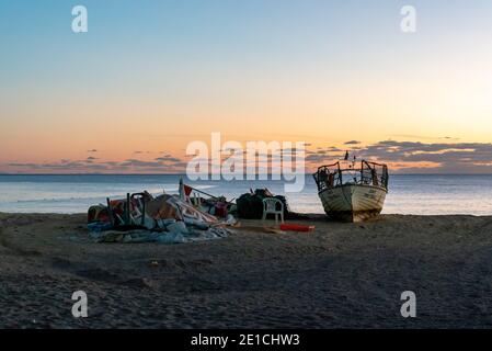 Amaraco da Pera, Portugal - 30 décembre 2020 : coucher de soleil à Praia do Pescadores, sur la côte de l'Algarve, au Portugal, avec bateau de pêche et filets Banque D'Images