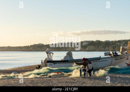 Amaraco da Pera, Portugal - 30 décembre 2020 : les pêcheurs de la Praia dos Pescadores se chargent et réparent leurs engins et filets Banque D'Images