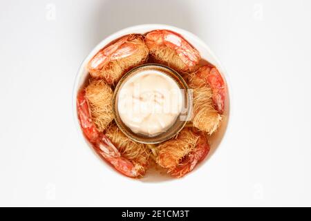 Vue aérienne d'un cube de crevettes frites enveloppées de pâtes Kataifi et servies avec une sauce dragon. Banque D'Images