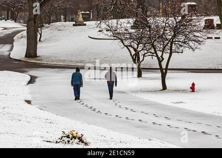 Detroit, Michigan - pendant la pandémie, deux personnes font une promenade tôt le matin socialement distancée dans le cimetière d'Elmwood. Banque D'Images