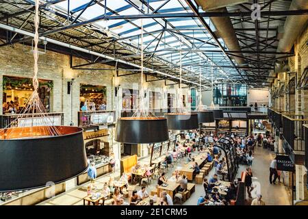Sous le toit du marché de l'alimentation et des magasins, la fourche, dans la capitale du Manitoba, Winnipeg. La maison d'hôtes au toit de verre avec les tables en bois est pleine Banque D'Images