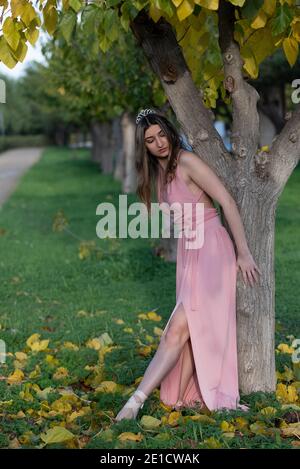 Jeune danseur vêtu d'une robe rose sur un ballet dansant les arbres à l'extérieur en automne Banque D'Images