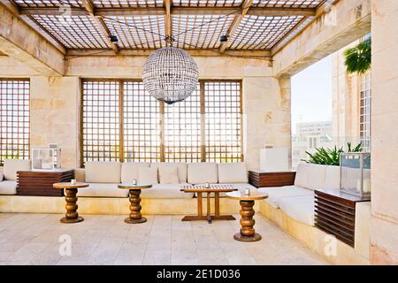 Salon extérieur sur le toit avec un grand lustre de type boule disco et décoration intérieure arabe Banque D'Images