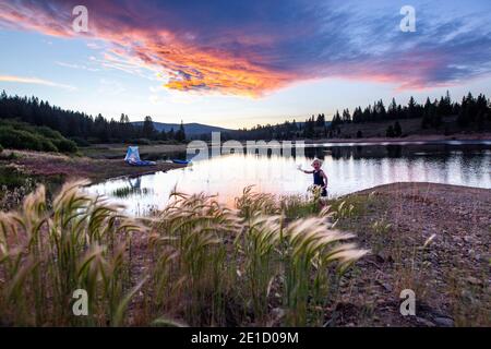 Fille jouant sur le bord du lac au coucher du soleil, Truckee, Californie, États-Unis Banque D'Images