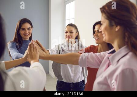 Équipe de femmes heureuses debout en cercle et se joignant à la main, se sentant unies et autonomes Banque D'Images