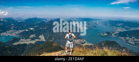 Les jeunes touristes avec un sac à dos apprécient le pic de Schafberg dans les alpes autrichiennes près de la ville de Salzbourg. Vue sur le lac Mondsee et une partie de WO Banque D'Images