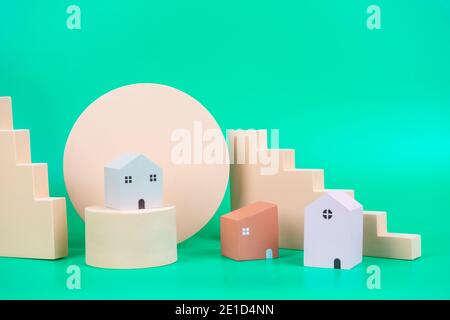 Petites maisons en bois et de couleur pastel géométrique affichent des podiums et formes sur fond vert clair Banque D'Images