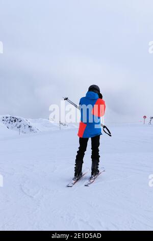 Jeune skieur met des lunettes pour une meilleure visibilité dans des conditions difficiles sur la piste située à la frontière entre l'Italie et l'Autriche, station de ski de Sillian. Banque D'Images