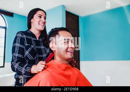 Client Latin MAN obtenant une coupe de cheveux par coiffeur dans la ville de Mexico Banque D'Images