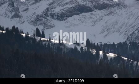 Crête de montagne enneigée, forêt de pins et falaise à Gsteig BEI Gstaad. Banque D'Images