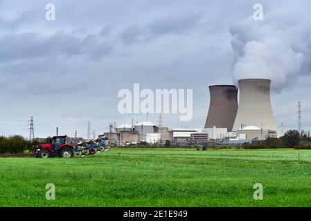 Un agriculteur plère le champ près de la centrale nucléaire Banque D'Images