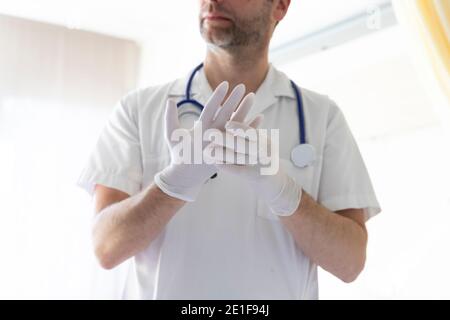 un médecin met des gants avant un examen Banque D'Images