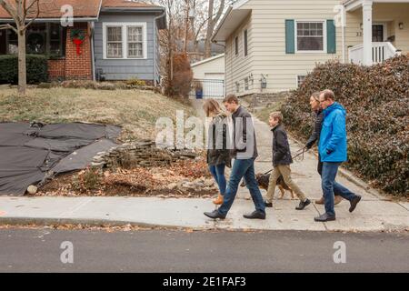 Une promenade en famille avec un chien à travers le quartier de banlieue Banque D'Images