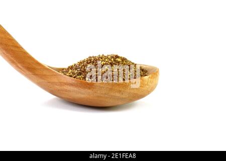 Graines de lin brunes broyées ou broyées (Linum usitatissimum) ou graines de lin dans une cuillère en bois isolée sur blanc. Banque D'Images