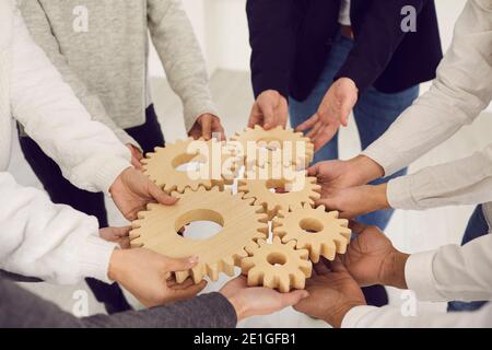 Équipe de personnes se joignant à Gears comme métaphore pour la collaboration et trouver des solutions créatives Banque D'Images