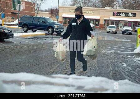Un travailleur masqué apporte des produits d'épicerie au bord du trottoir à une voiture du Lunds Byerlys Grocery Store pendant la pandémie de Covid. St Paul Minnesota MN États-Unis Banque D'Images