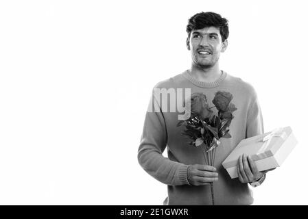 Happy young man smiling Persan tout en maintenant des roses rouges et boîte-cadeau prêt pour la Saint-Valentin Banque D'Images