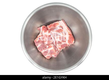 Côtes de porc douces de rechange dans un bol en acier inoxydable, image isolée sur fond blanc, vue de dessus côtes de porc fraîches de rechange. Banque D'Images