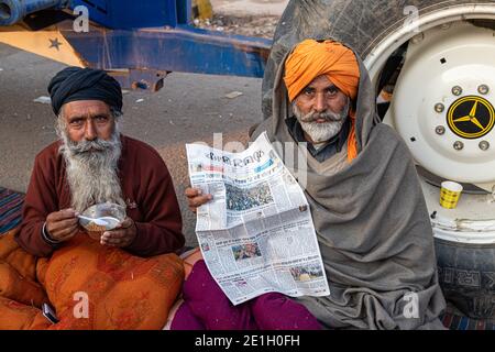 portrait d'un groupe d'agriculteurs lisant un article de presse pendant la manifestation. ils protestent contre la nouvelle loi sur les agriculteurs en inde. Banque D'Images
