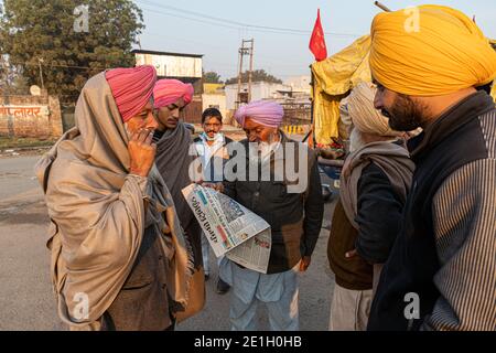 portrait d'un groupe d'agriculteurs lisant un article de presse pendant la manifestation. ils protestent contre la nouvelle loi sur les agriculteurs en inde. Banque D'Images
