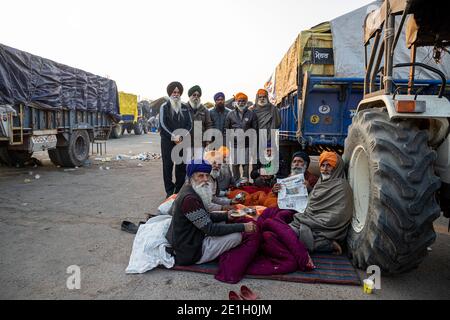 portrait d'un groupe d'agriculteurs lisant un article de presse pendant la manifestation. ils protestent contre la nouvelle loi sur les agriculteurs en inde. Banque D'Images