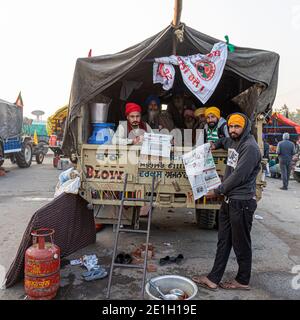 portrait d'un groupe d'agriculteurs lisant un article de presse pendant la manifestation. ils protestent contre la nouvelle loi sur les agriculteurs en inde. Banque D'Images