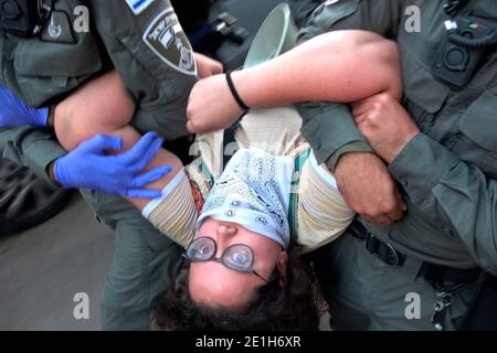 Les policiers transportent un manifestant après que des manifestants ont brisé des barricades de police devant la résidence officielle du Premier ministre israélien lors d'une manifestation contre le Premier ministre Benjamin Netanyahu à la suite de son inculpation pour corruption à Jérusalem, en Israël Banque D'Images