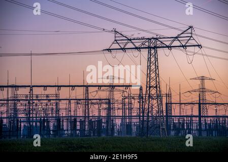 Wolmirstedt, Allemagne. 19 décembre 2020. Un lever de soleil coloré s'annonce à la station de transformation avec ses pylônes d'électricité visibles de loin. Credit: Stephan Schulz/dpa-Zentralbild/ZB/dpa/Alay Live News Banque D'Images