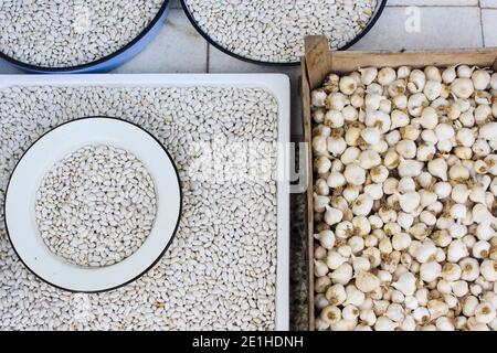 Haricots blancs cultivés à la maison et récolte d'ail séchant dans des plateaux à l'extérieur de l'hiver, Bulgarie Banque D'Images