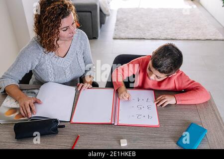 Mère aidant son fils à faire des mathématiques à la maison Banque D'Images