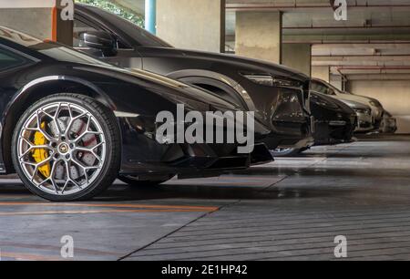 Bangkok, Thaïlande - 06 janvier 2021 : le côté de la roue de la voiture de sport Lamborghini noire garée dans le parking. Mise au point sélective. Banque D'Images