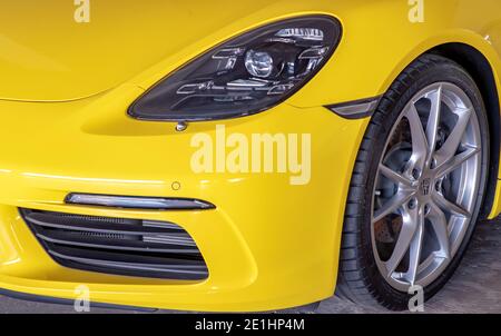 Bangkok, Thaïlande - 06 janvier 2021 : gros plan des phares et de la roue de voiture de la voiture de sport Porsche jaune garée dans le parking. Mise au point sélective. Banque D'Images