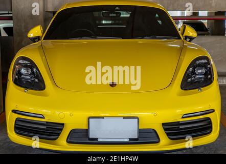 Bangkok, Thaïlande - 06 janvier 2021 : devant la voiture sportive Porsche jaune garée dans le parking. Mise au point sélective. Banque D'Images