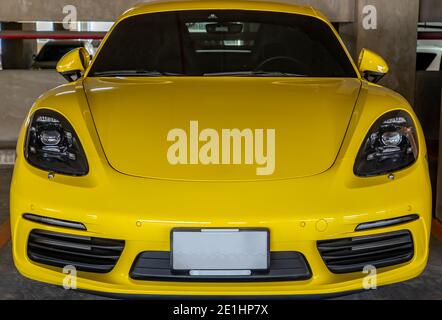 Bangkok, Thaïlande - 06 janvier 2021 : devant la voiture sportive Porsche jaune garée dans le parking. Mise au point sélective. Banque D'Images