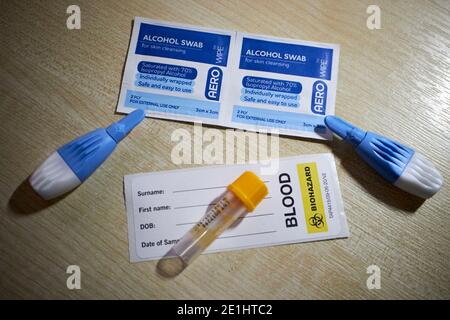 les tampons alcoolisés laclettes le tube de prélèvement sanguin et l'étiquette du commerce kit de test sanguin d'anticorps covid-19 pour le dépistage à domicile du coronavirus anticorps reçus au royaume-uni Banque D'Images